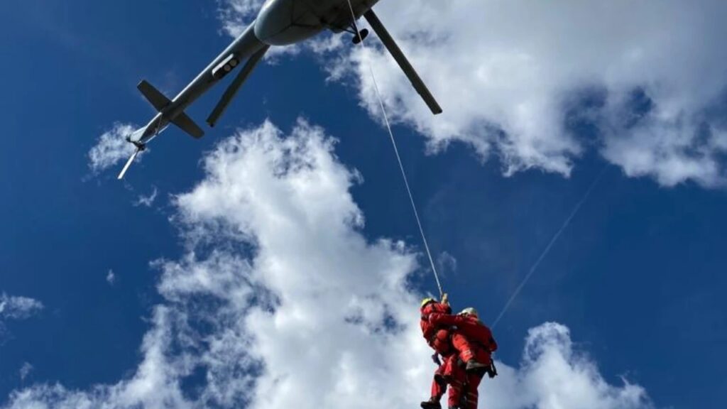 Helikopter prevozi spasioce na nepristupačnom terenu.