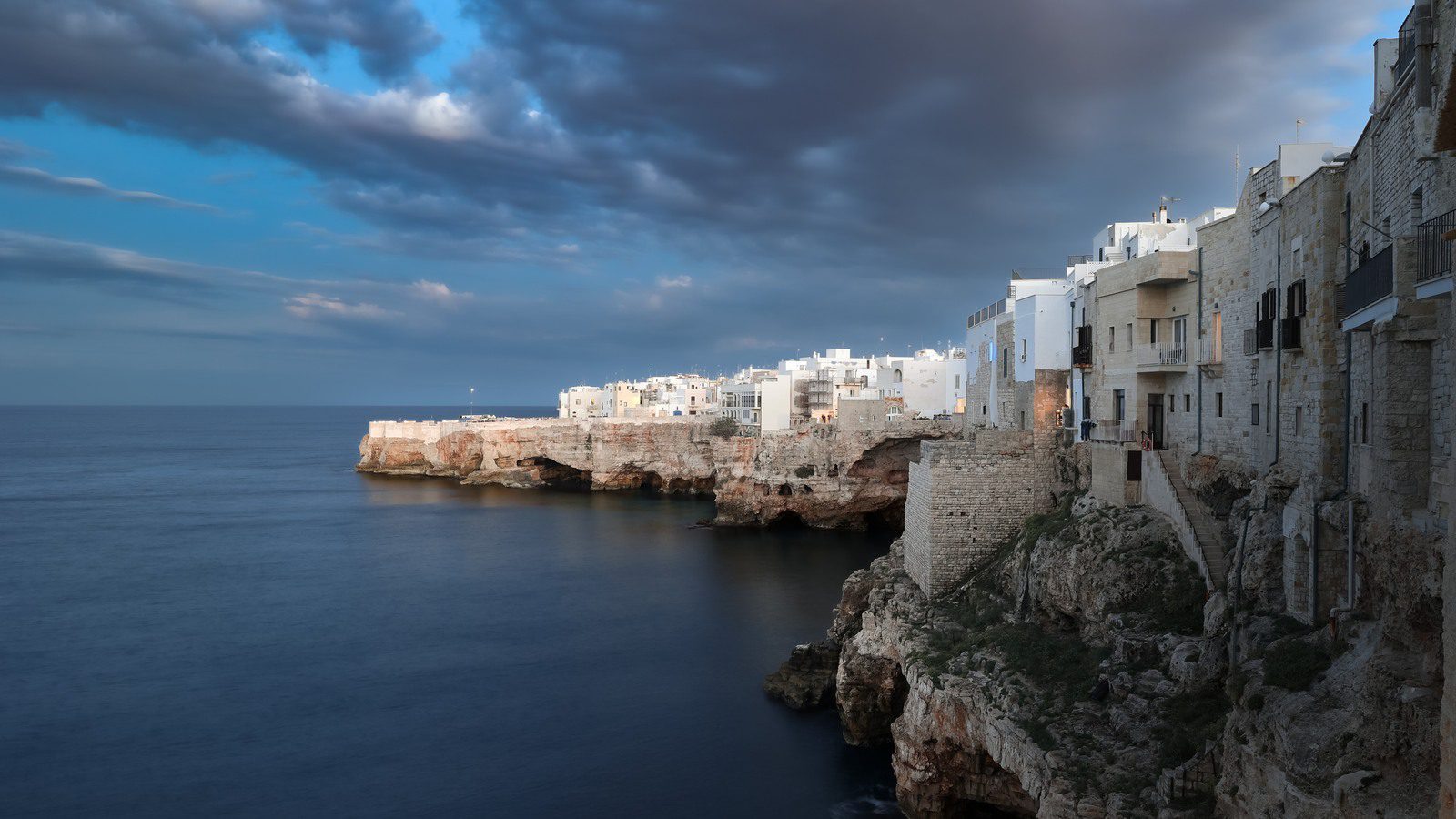 Večernji pogled na Polignano a Mare na liticama uz more.